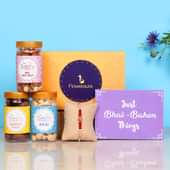 Chocolicious Dry Fruits N Rakhi Hamper - One Pearl Rakhi with Roli and Chawal and Mixed Dry Fruits and Cashews and Choco Cashews and One Floweraura Signature Box