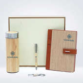 A wooden notebook, pen, and water bottle and keychains 