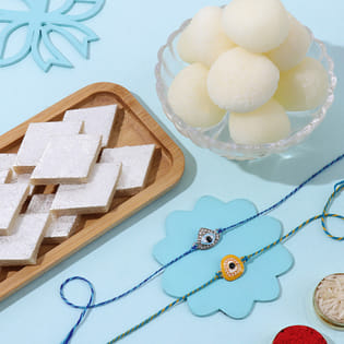 Evil Eye Rakhi Duo With Indulging Kaju Katli N Rasgulla