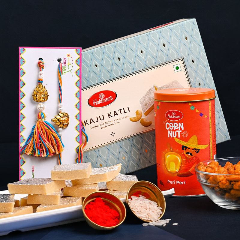 Lumba Rakhiwith Sweets for Bhaiya bhabhi Online Delivery - Delicious Kaju Katli n Corn Nut With Colourful Bhaiya Bhabhi Rakhi