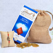 Lindt Dry Fruit Hamper - One Peacock Rakhi with Complimentary Roli and Chawal and 100gm Raisins in Jute Potli and Lindt Extra Creamy Milk Chocolate
