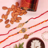 Nut Three Rakhi Set Combo - Set of 3 Designer Rakhi with Complimentary Roli and Chawal and 100gm Almonds in Red Floweraura Container