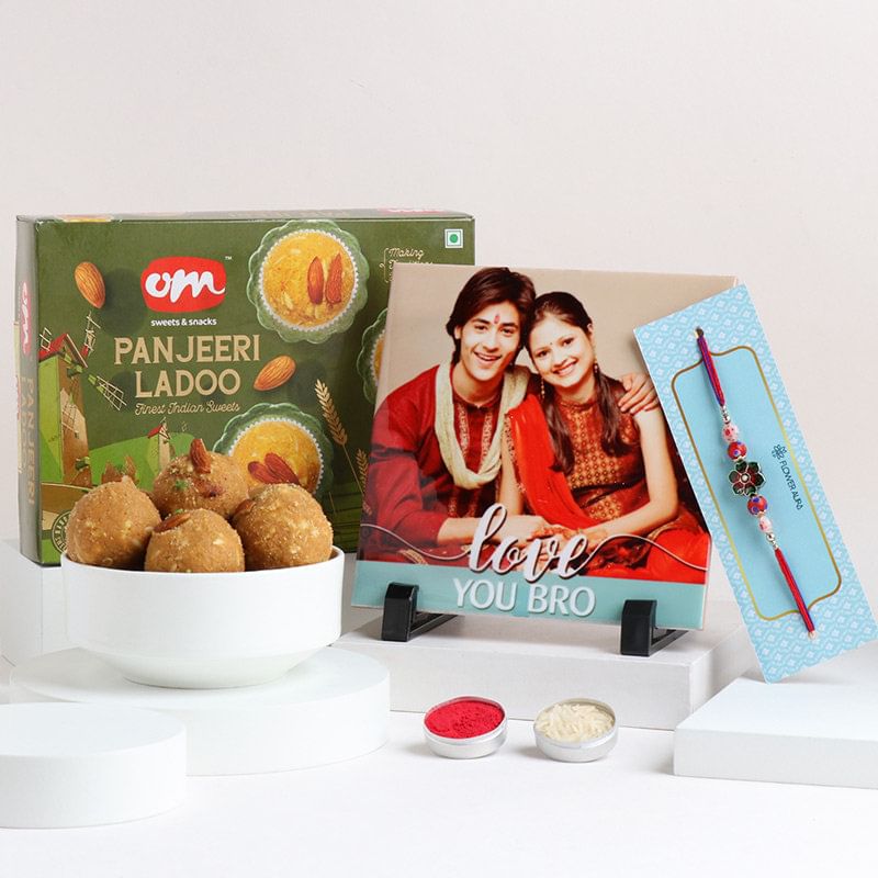 Om Sweets Panjeeri Laddoo With Flowery Rakhi N Photo Tile