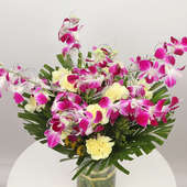 Orchids Carnations Glass Vase With Cake: Arrangement of 4 Purple Orchids and 10 Yellow Carnations