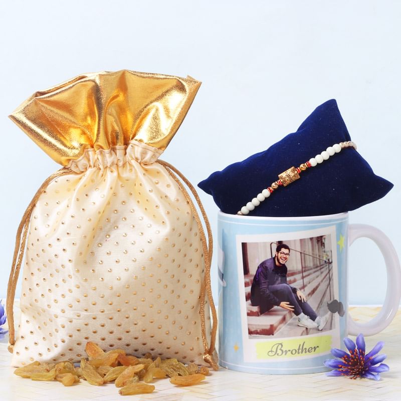 Personalised Rakhi Hamper - One Metal Rakhi with Complimentary Roli and Chawal and Personalised Brother Mug and 100gm Raisins in Cream Potli and One personalised ceramic mug