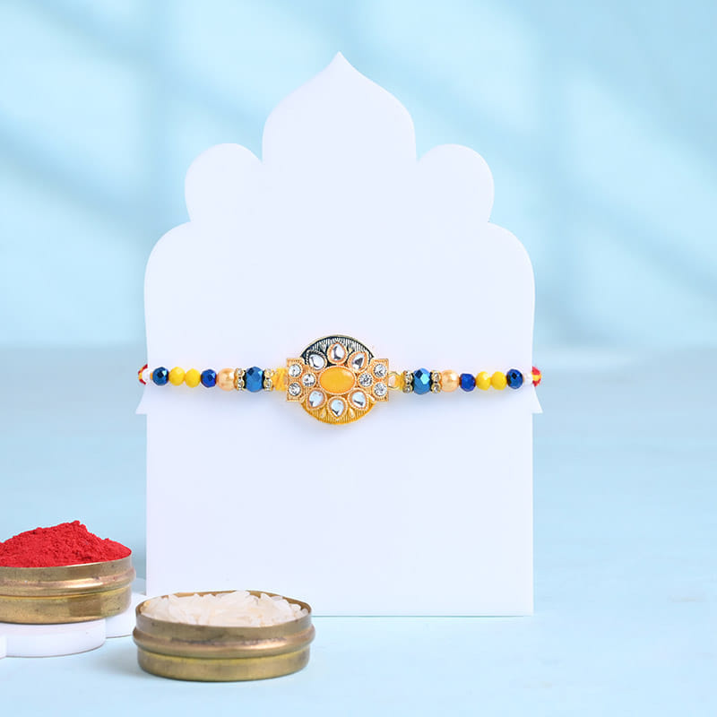 Radiant Floral Stone Rakhi With Besan Ladoos