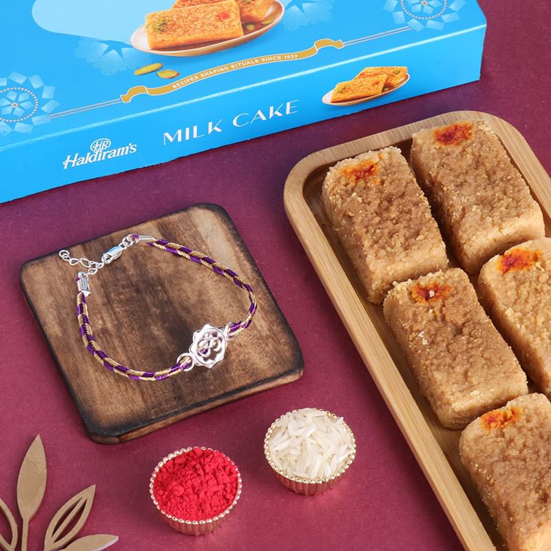 Silver Om Flower Rakhi N Milk Cake Combo