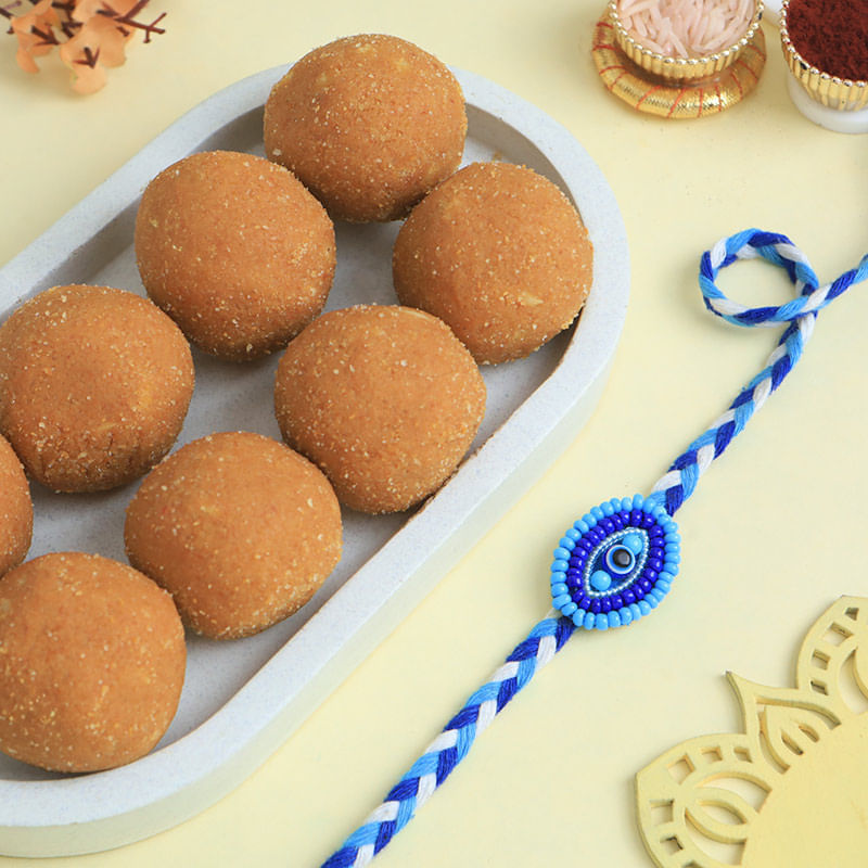 Stunning Evil Eye Rakhi With Besan Ladoos