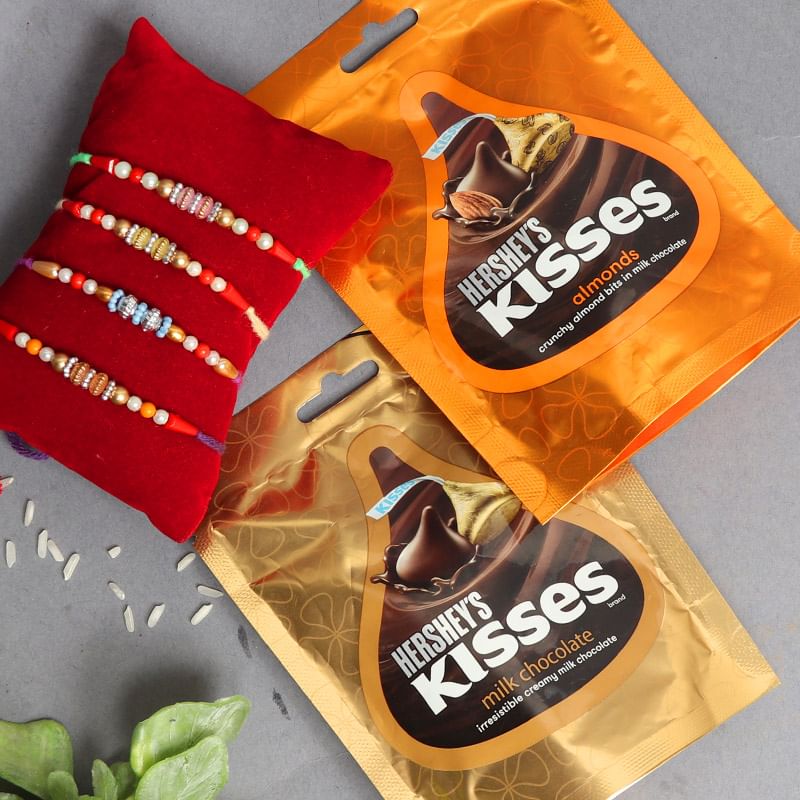 Tempting Rakhi Combo - Set of 4 Designer Rakhis with 2 Hersheys Kisses - 33gm each and Complimentary Roli and Chawal