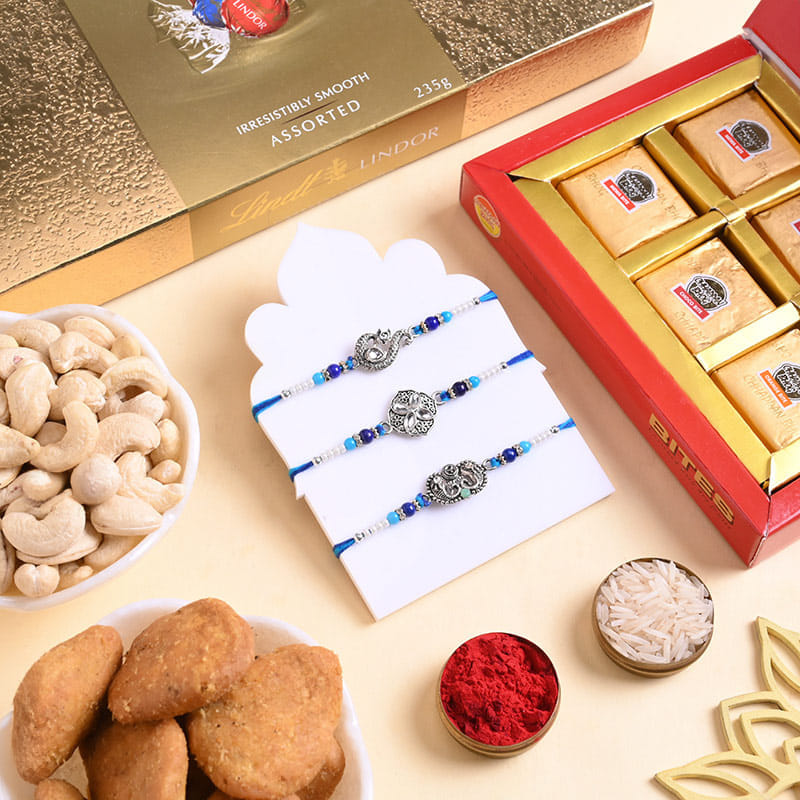 Three Silver Charm Rakhis N Treats Hamper