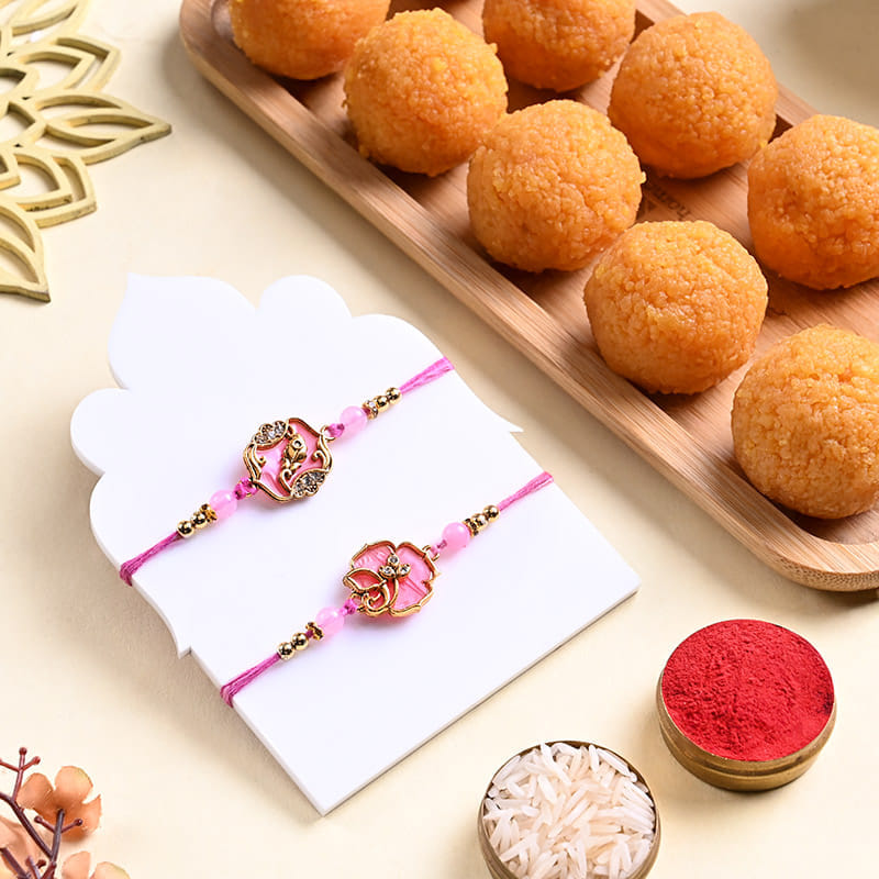 Two Pink Floral Rakhis With Motichoor Ladoos